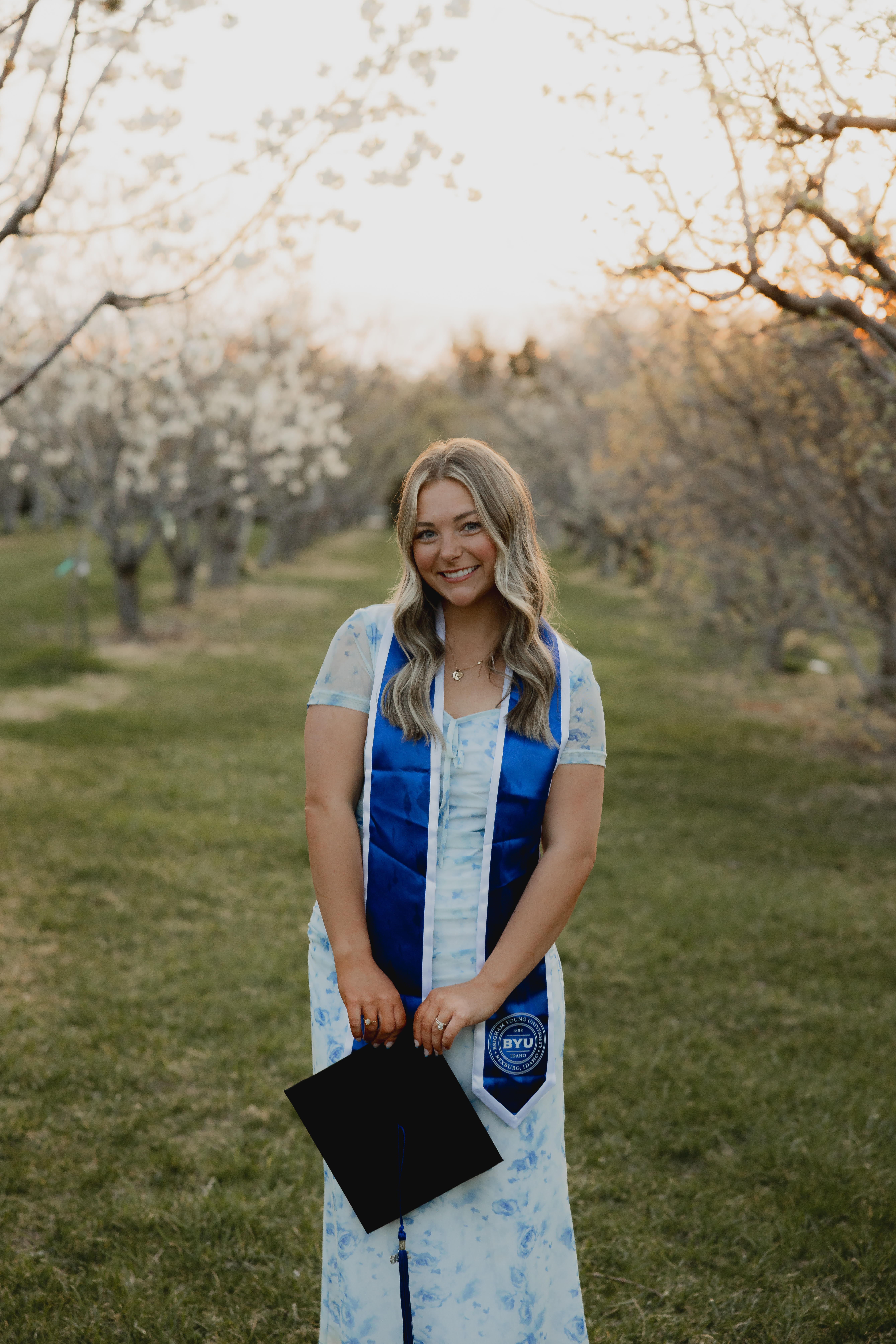 Photo of Kara in a grove with mortarboard
